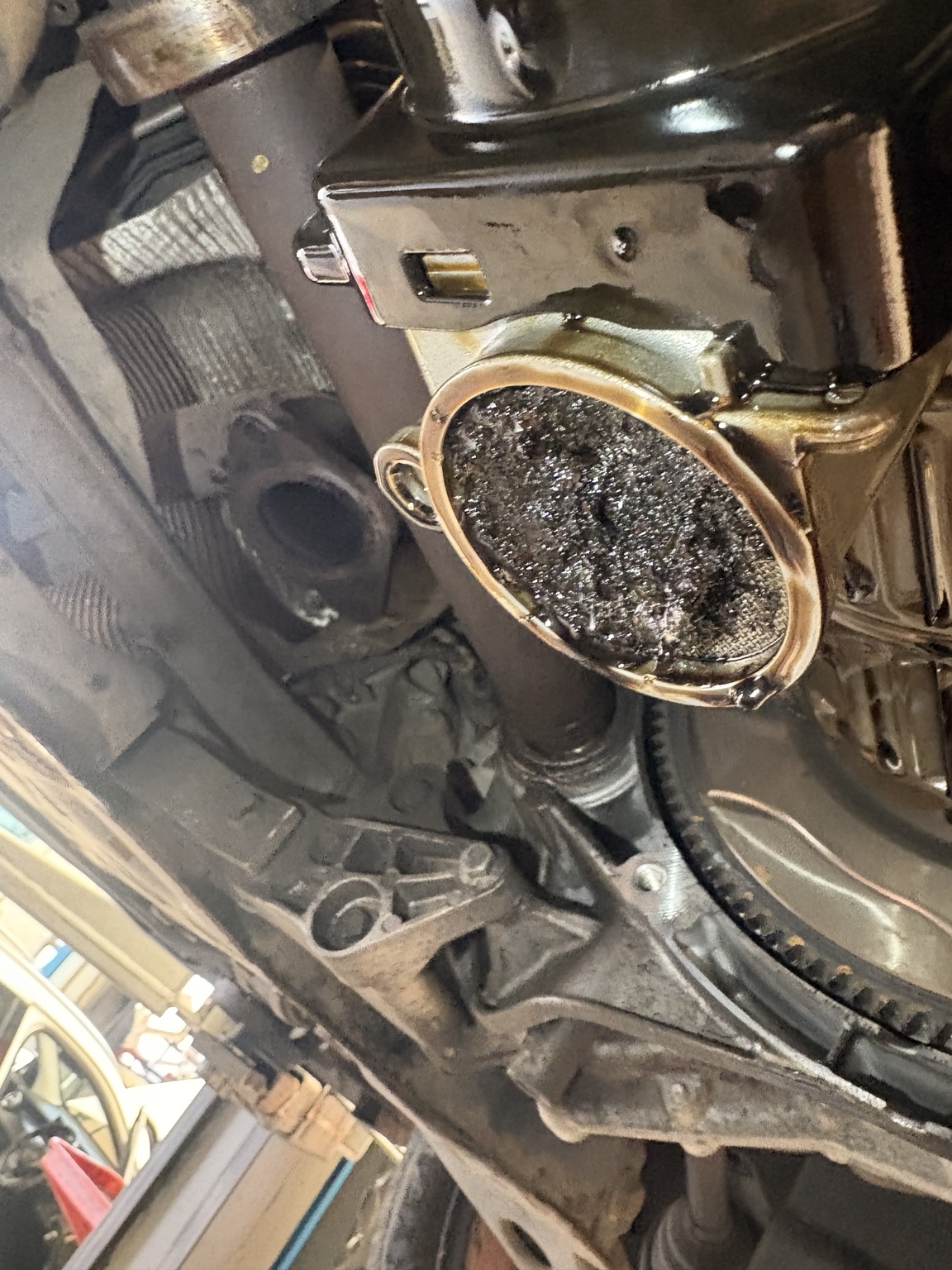 Oil pickup strainer restricted by wet belt debris